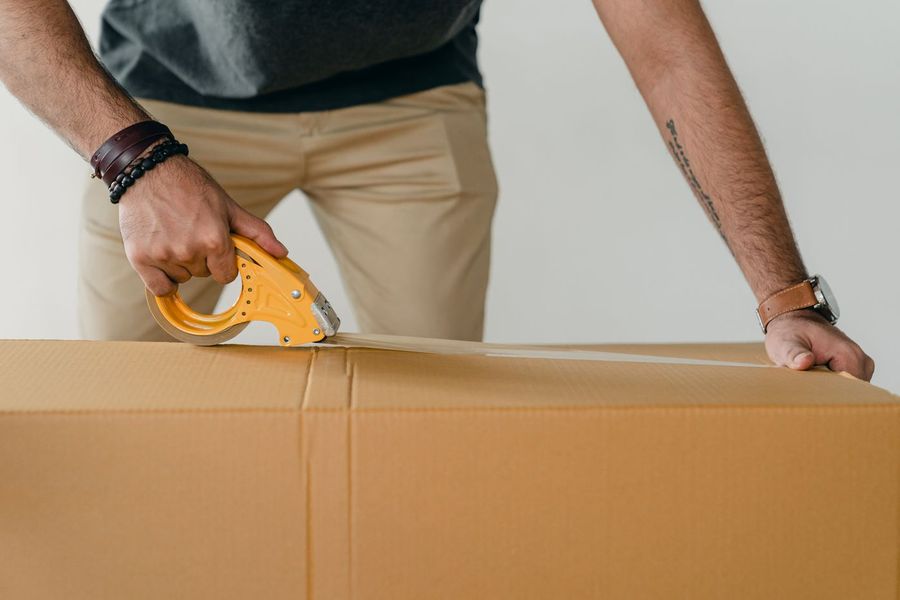 Bestelling van een webshop wordt ingepakt: een doos wordt dichtgetapet voor verzending